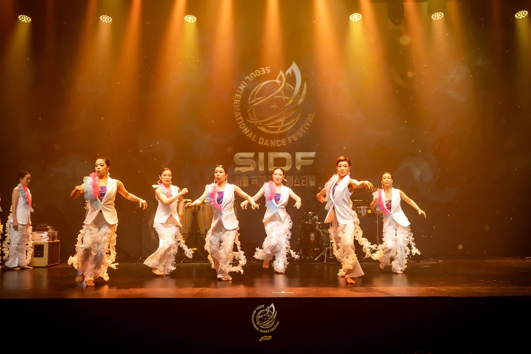 Dancers moving together on the SIDF 2026 Saturday performance stage as the audience watches