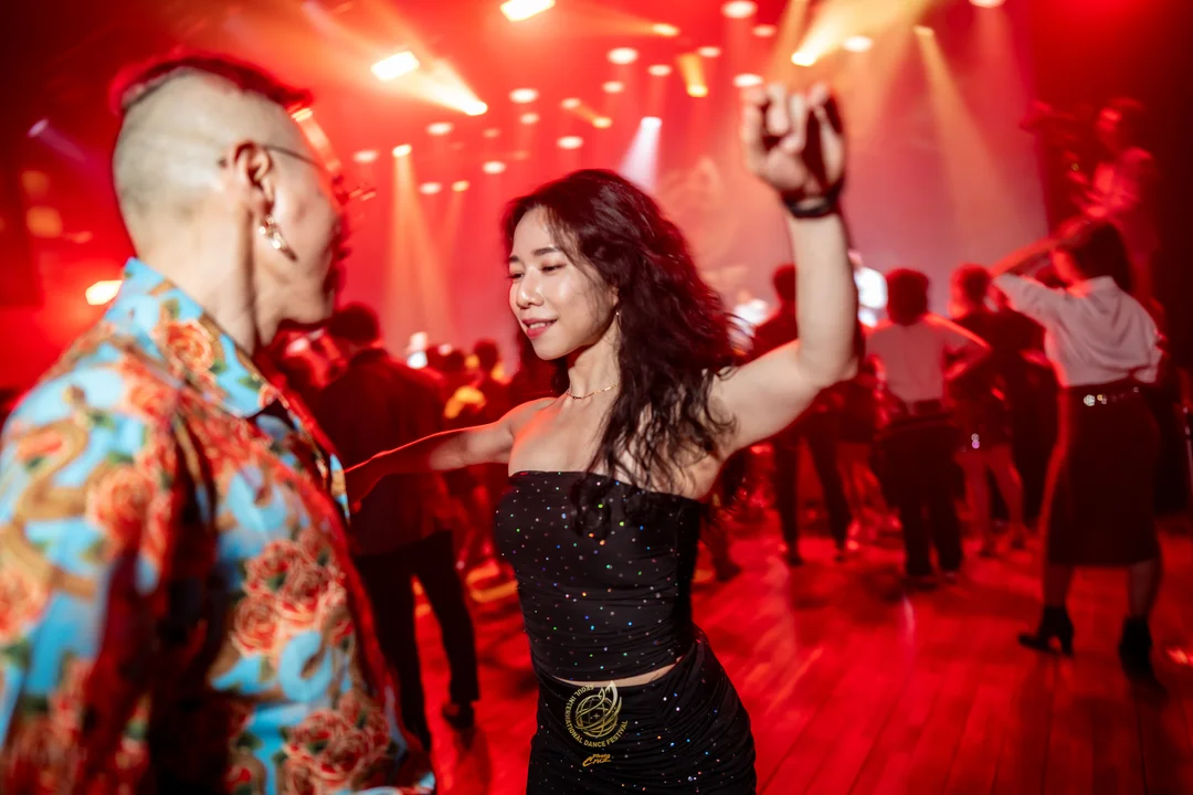 Amplia pista con muchos participantes bailando juntos en el social del sábado de SIDF 2026